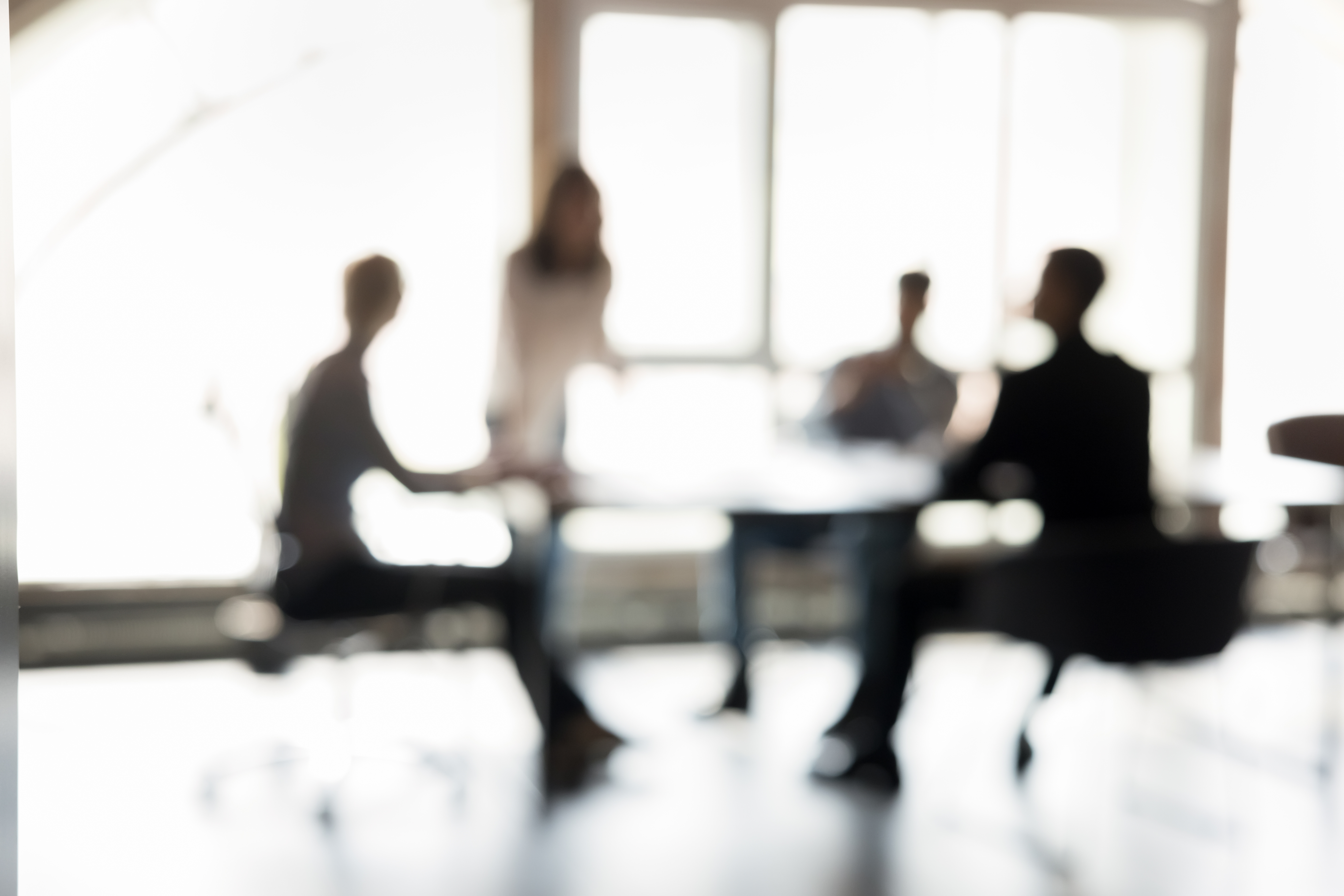 Blurred silhouettes of people participate in business meeting