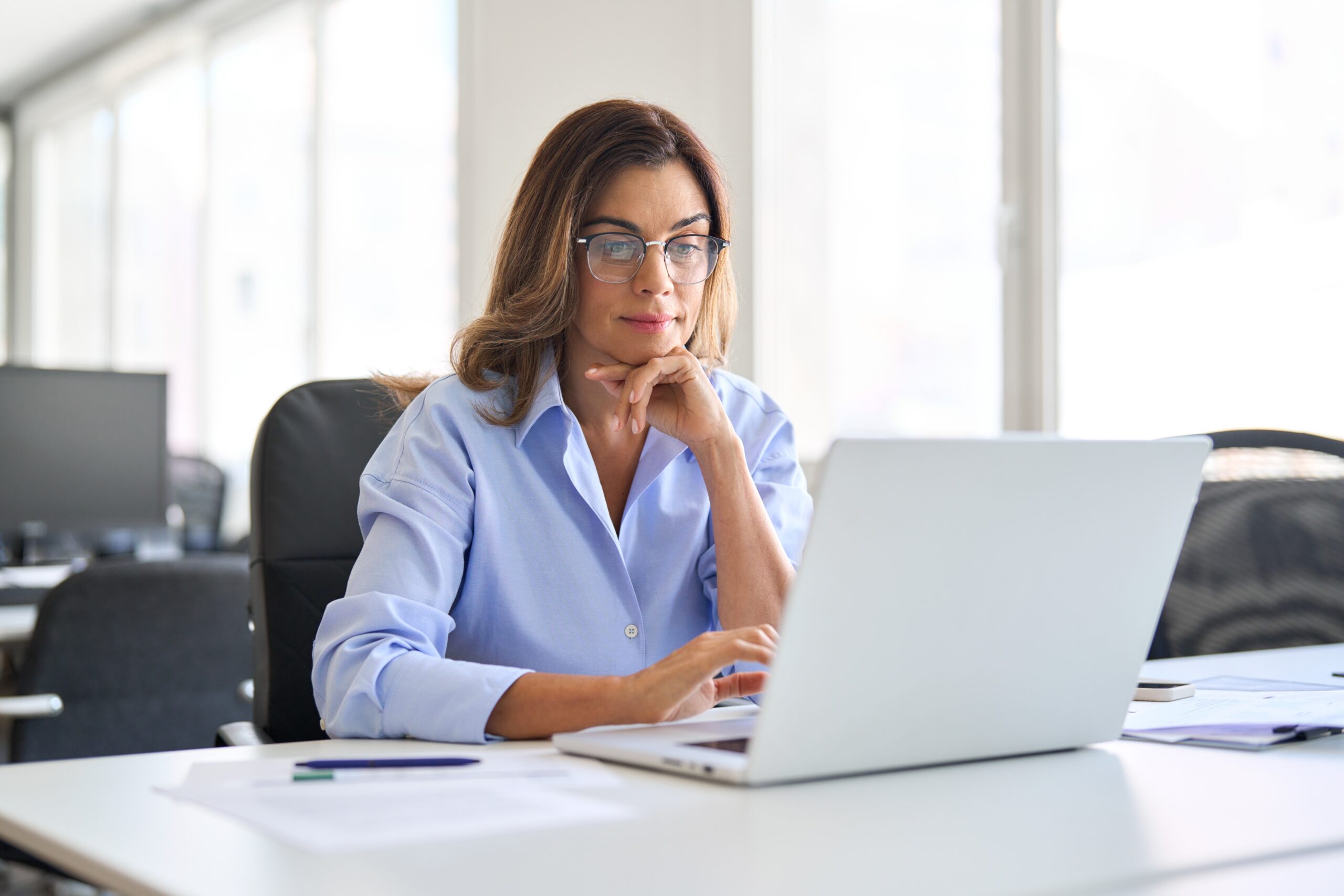 Busy-elegant-middle-aged-business-woman-using-laptop