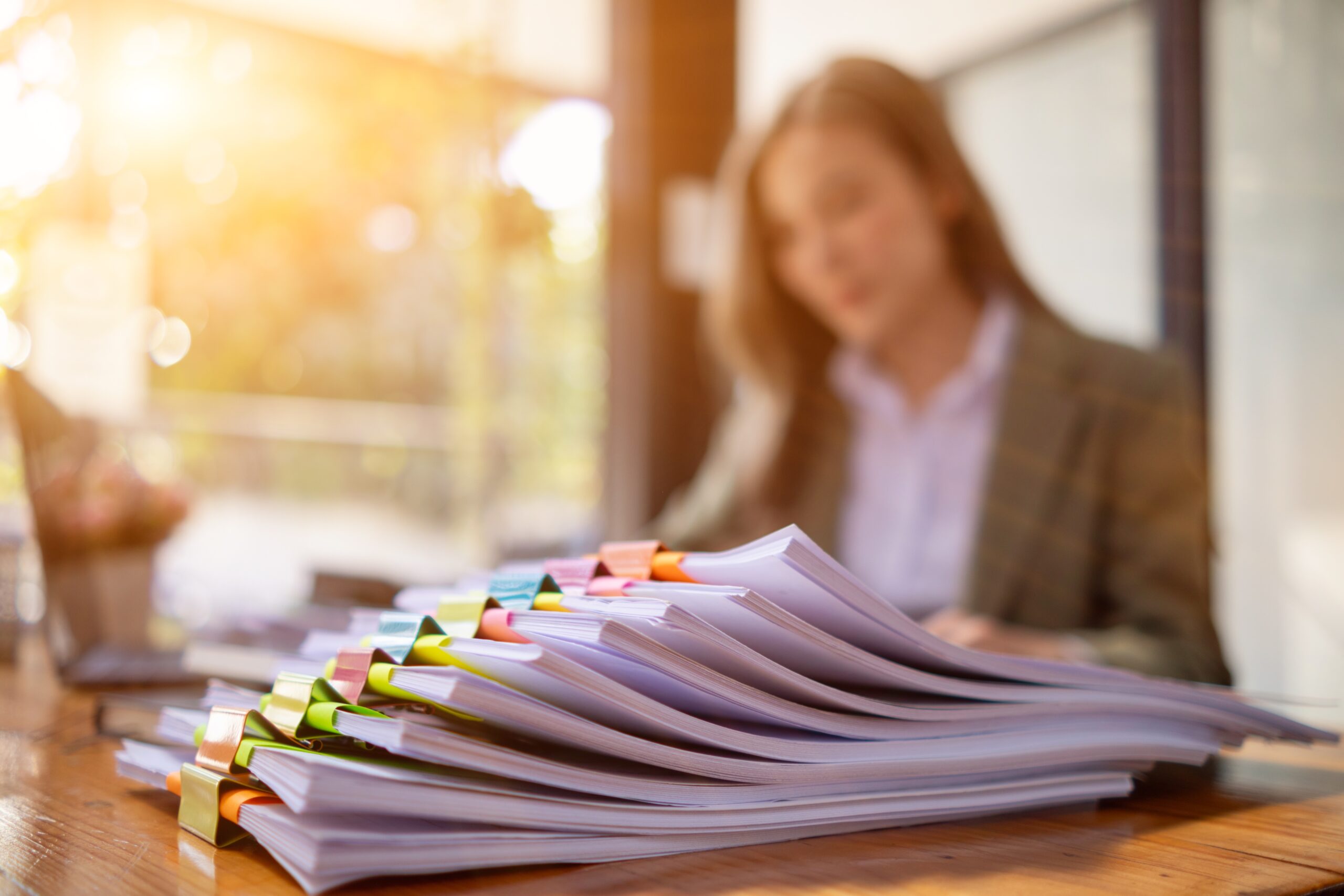 stack of documents on secretary desk