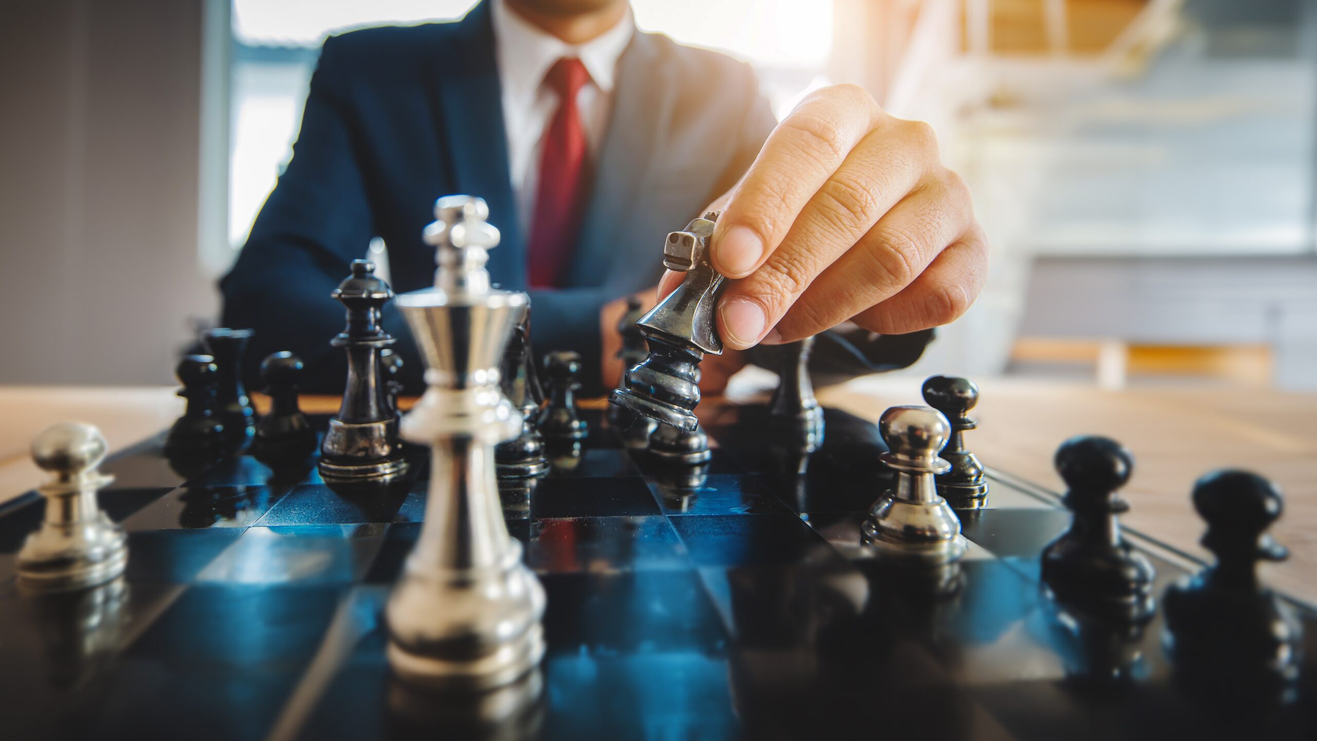 Businessman moving chess piece on chess board game